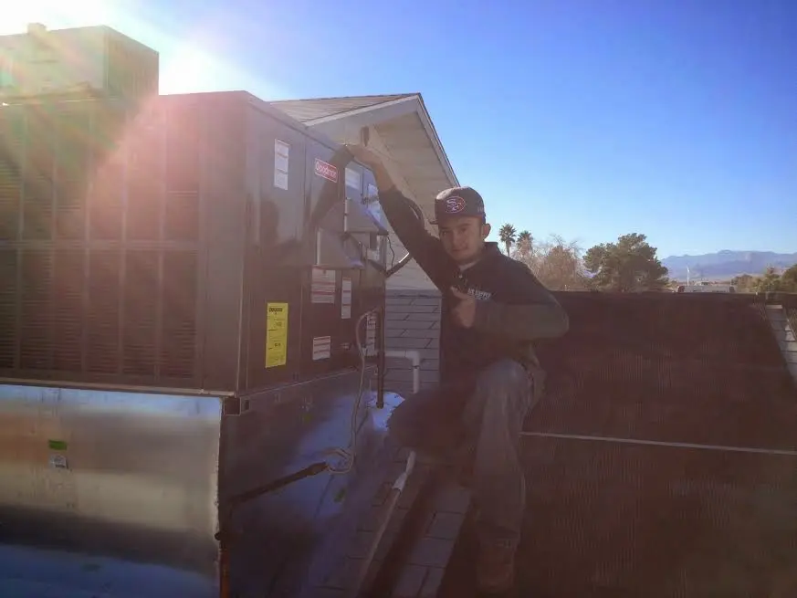 HVAC technician performing Air Duct Cleaning on a rooftop unit in Issaquah